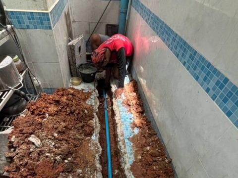 ทำความสะอาดพื้นและขุดร่องเพื่อวางท่อประปา PVC